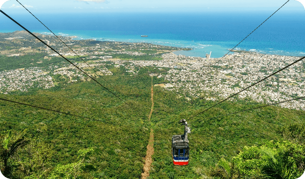 View-of-Puerto-Plata,-forest,-ocean,-and-the-cable-car-from-the-top-of-Mount-Isabel-de-Torres---cable-car-has-partly-descended-1506089833_5892x3928@2x